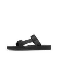 Svart sandal med en platt gummisula, med justerbara tygremmar. Enkelt mönster med en strukturerad fotsäng och sidodelar med logotyp.