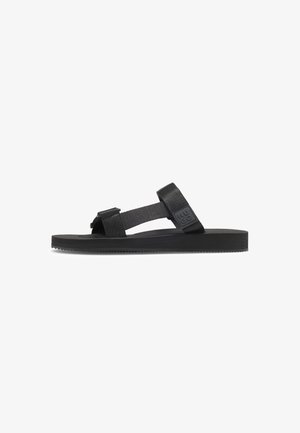 Sort sandal med en flad gummisål, der har justerbare stofremme. Enkel design med en struktureret sål og brandingdetalje på siden.