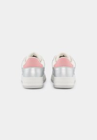 Sneaker basse con tomaia sintetica argento, dettagli rosa sul tallone e suola in gomma bianca. Presenta il logo sul tallone e una texture liscia.