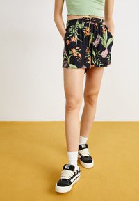 Schwarze Shorts mit einem floralem Muster aus orangefarbenen und gr�ünen Blättern, ausgestattet mit einem elastischen Bund, seitlichen Taschen und einer lockeren Passform.