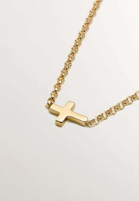 Collar de cadena de oro con un colgante de cruz pulido de acabado suave y bordes redondeados, que exhibe eslabones de cadena entrelazados.