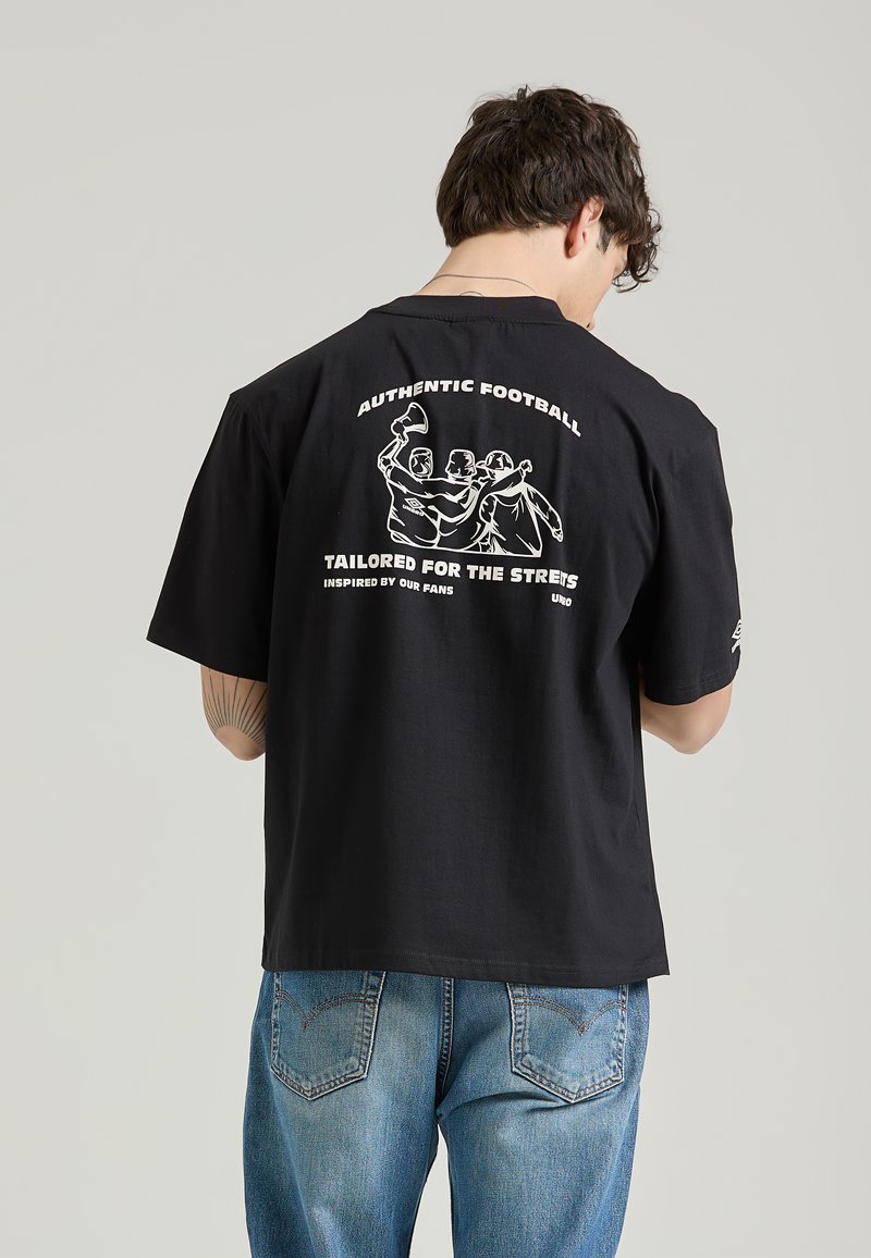 Svart t-shirt med kort ärm som har en vit grafik på baksidan med text och figurer. Tillverkad i bomull med en avslappnad passform.