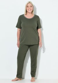 Conjunto de pijama de algodón verde que incluye una camiseta de manga corta con ribete de contraste y pantalones con estampado de lunares y cintura elástica.