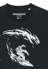 T-shirt en coton noir avec un graphique blanc représentant un astronaute en train de surfer sur une vague d'étoiles. Design à col rond et manches courtes.