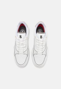 White sneakers featuring a smooth leather upper, perforated toe, padded tongue with logo, and grey accents on the sides and heel.