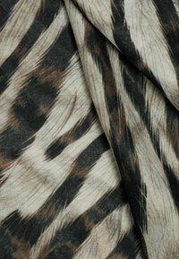 Lightweight fabric featuring a beige base with black and brown abstract stripes, creating a textured, layered appearance.