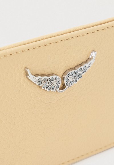 Πορτοφόλι σε ταμπά δέρμα με υφή και ασημένιο διακοσμητικό φτερό με διάφανα κρύσταλλα. Οι ραμμένες άκρες ολοκληρώνουν το σχέδιο.