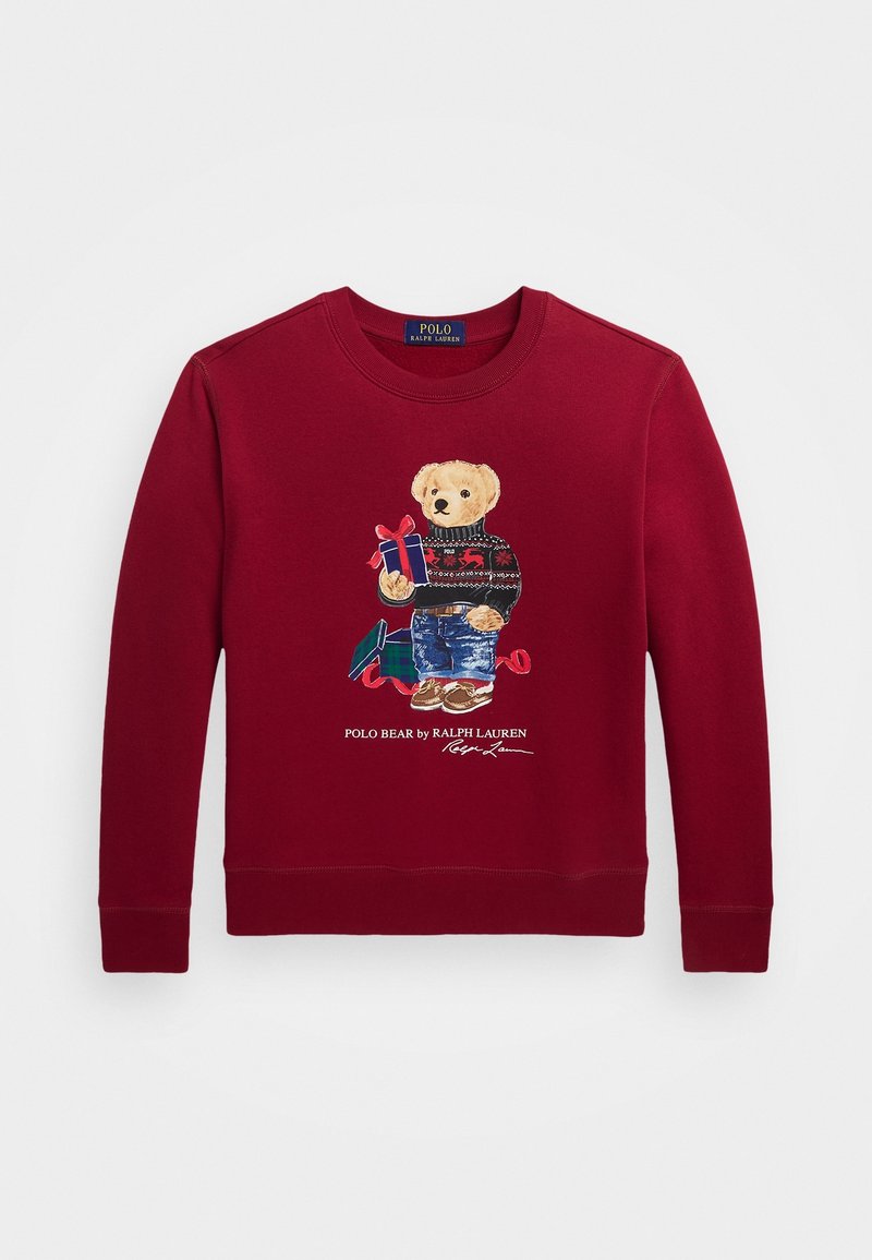 Sweat-shirt rouge à manches longues avec un ours en peluche portant un pull et un jean, tenant un cadeau emballé, et le texte "POLO BEAR by RALPH LAUREN."