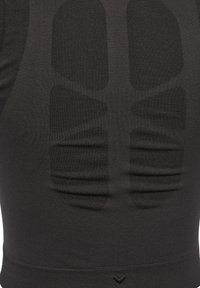 Czarny sportowy top wykonany z teksturowanej tkaniny, wyposażony w podszyte sekcje dla wsparcia. Gładki, dopasowany design z wykończeniem bez szwów.