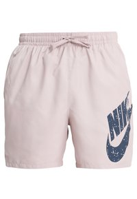 Vaaleanpunaiset Nike-uimashortsit, joissa on joustava vyötärö, nyöri ja suuret tummansiniset logo, jossa on roiskepinta edessä.