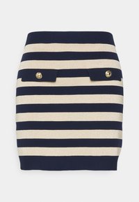 Navy ja vaaleanbeige vaakasuoraraidallinen neulemini hame, jossa on kaksi etuflappia, jotka on kiinnitetty kullalla napilla.