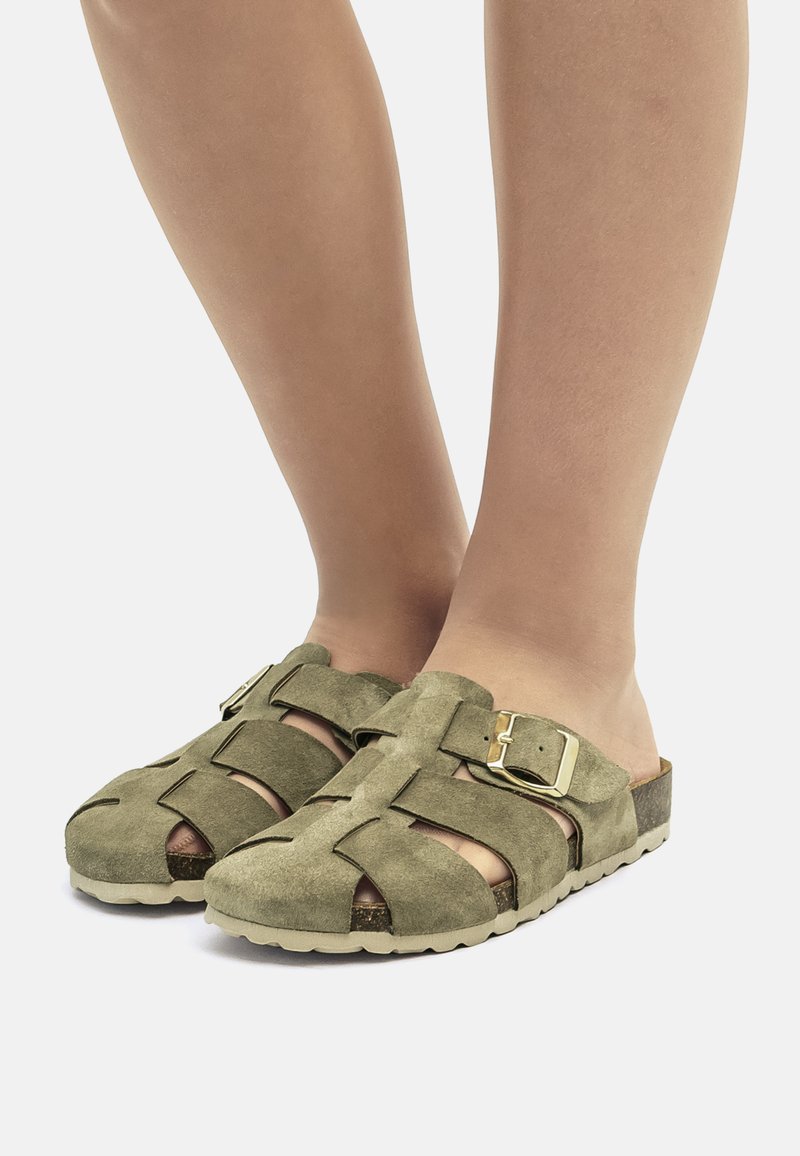 Olijfgroene suède clogs met een open teenontwerp, kruisbanddetails, een zijgesp en een gestructureerde beige rubberen zool.