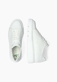 Baskets blanches en cuir texturé avec bout rond, devant à lacets et semelle en caoutchouc plate. Présente un logo vert sur la semelle intérieure.