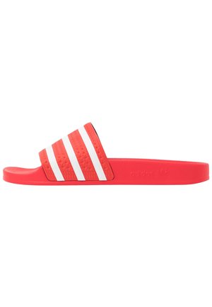Sandale slide rouge Adidas avec trois bandes blanches sur la bride texturée et une semelle plate.