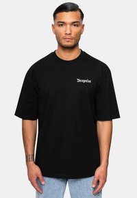 Sort bomulds t-shirt med korte ærmer og rund hals, med hvid "Dropsize" tekst på venstre bryst. Casual pasform med en glat tekstur.