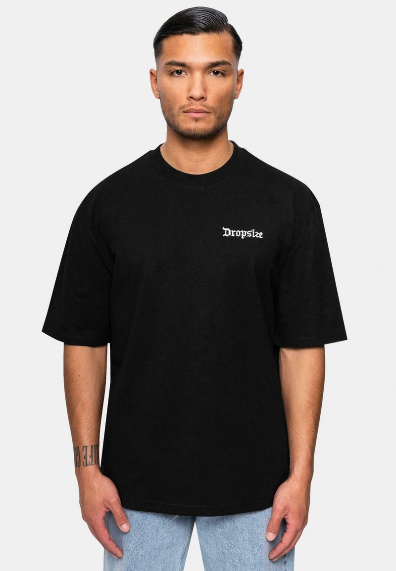 Sort bomulds t-shirt med korte ærmer og rund hals, med hvid "Dropsize" tekst på venstre bryst. Casual pasform med en glat tekstur.