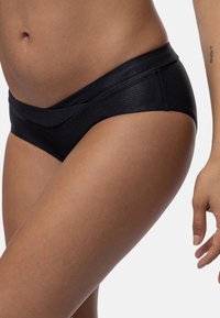 Melnas rakstu hipster bikses ar gludu faktūru un platu jostiņu, piedāvājot zemu jostas griezumu un ikdienišķu piegriezumu.