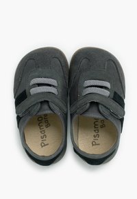 Un paio di scarpe per bambini grigie con cinturini in velcro e lacci grigi, in morbido materiale scamosciato, con sottopiedi imbottiti color cammello.