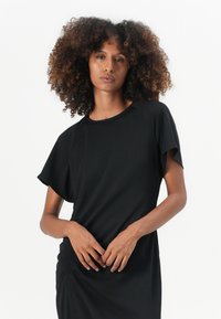 Black dress with a relaxed fit, short raglan sleeves, and gathered detail at the waist. Smooth, lightweight fabric with a subtle sheen.