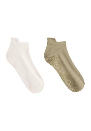 O pereche de șosete joase cu aderență, una albă și una bej, cu puncte texturate din cauciuc pe tălpi pentru suport antiderapant.