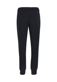 Svarta byxor i en mjuk, lättviktig tyg. De har ett elastiskt midjeband, bakfickor och avsmalnande muddar med dragkedjor vid anklarna.