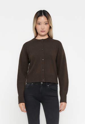Bruine gebreide cardigan met een ronde hals, geribde manchetten en zoom, voorzien van een knoopsluiting aan de voorkant. Draag het over zwarte jeans.