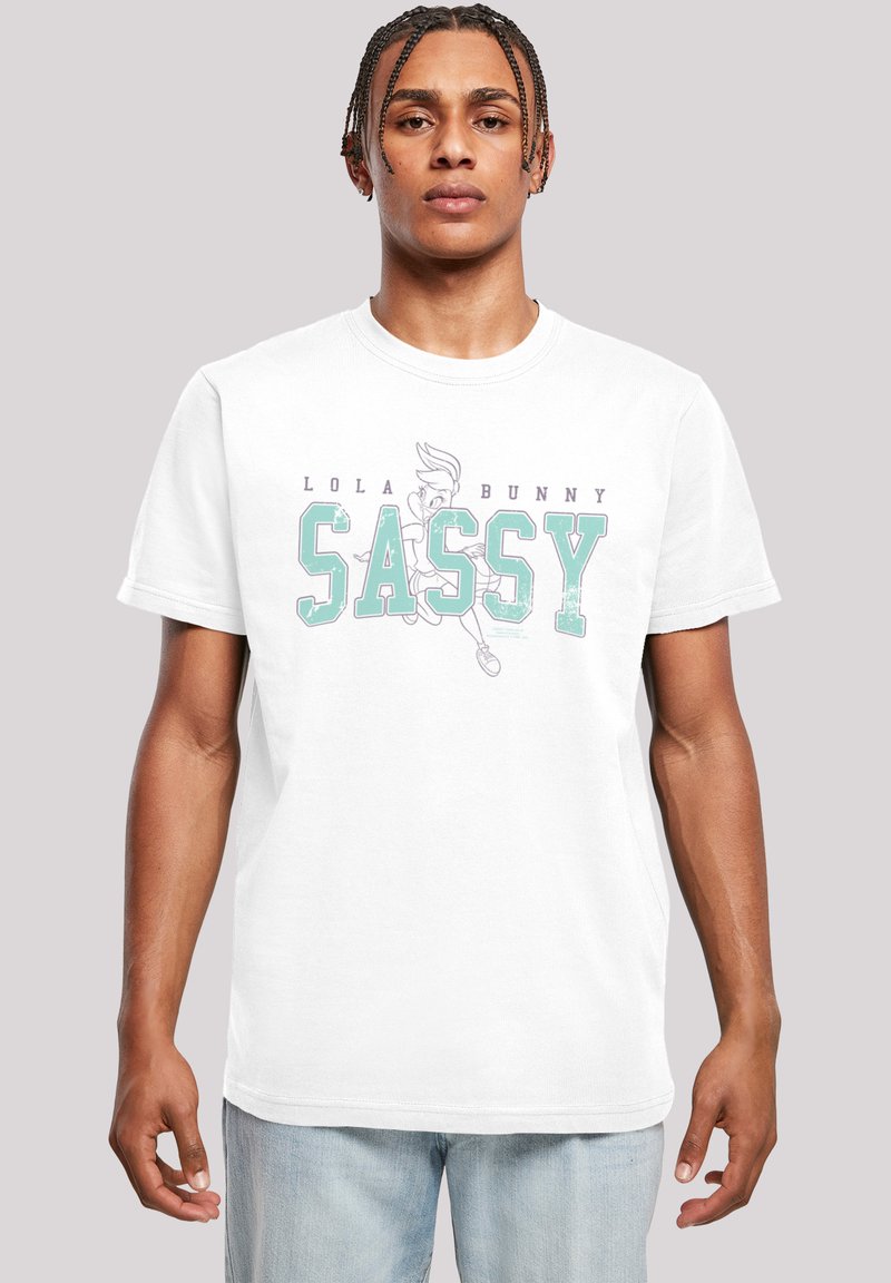 Hvit bomull T-skjorte med grafisk trykk av Lola Bunny og ordet "SASSY" i teal med slitte detaljer. Løs passform, korte ermer.