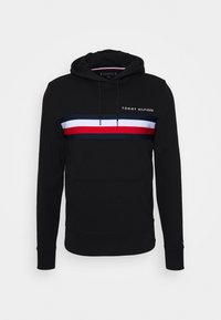 Hoodie noir en coton avec une poche avant, arborant une bande bleue, blanche et rouge sur la poitrine et le logo "TOMMY HILFIGER".