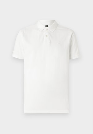 Hvit polo-skjorte laget av bomull, med en tre-knaps placket og korte ermer. Inkluderer en subtil logo på venstre bryst.