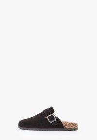Sorte ruskinds slip-on sko med en korkfodersål, featuring en spænde detaljer og rund tå. Glat tekstur med en flad sål.