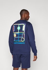Marineblaues Sweatshirt mit einem bunten Grafikdesign auf der Rückseite, Text "PORTIVAMENTE" und gerippten Bündchen und Saum.