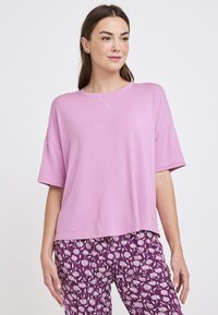 Camiseta rosa de manga corta con cuello redondo y un ajuste relajado. Textura suave con un pequeño detalle de costura en el cuello.