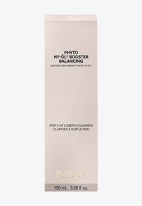 Babor Phyto Hy-Öl Booster dans une boîte de couleur claire. Le texte noir détaille le nom du produit et les instructions d'utilisation. Comprend un logo doré. Taille de 100 mL.