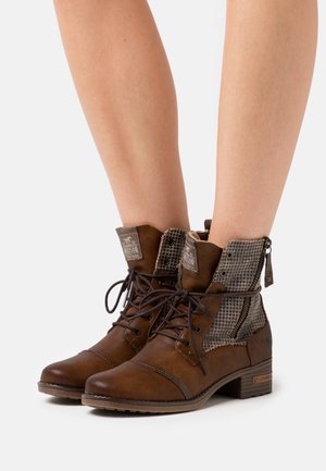 Bottines en cuir brun avec des accents textiles à carreaux, à lacets, fermeture éclair sur le côté et petit talon empilé.