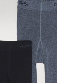 Due paia di leggings: uno blu scuro e uno nero. Entrambi presentano cinture elastiche con cuciture a contrasto e un tessuto testurizzato.