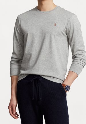 Grijze lange mouw t-shirt van katoen met een ribbelstructuur, voorzien van een klein bruin polo logo op de linkerkant van de borst, gecombineerd met marineblauwe joggingbroek.