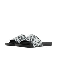 Sandali slide in bianco e nero con una tomaia sintetica a motivo e suola testurizzata. Caratterizzati da una fascia larga e un design con punta aperta.