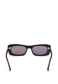 Lunettes de soleil rectangulaires noires avec des verres teintés foncés et des branches légèrement courbées sur fond blanc.