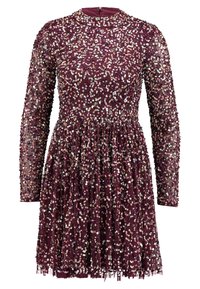 Lila långärmad klänning med iriserande paljetter överallt och en samlad midja som skapar en utsvängd kjol.