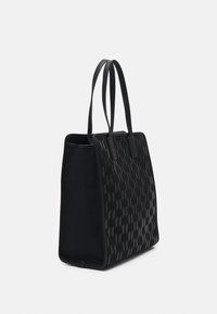 Czarna torba na ramię wykonana z gładkiego materiału, z teksturowanym wzorem logo i solidnymi płaskimi ramiączkami. Szeroki prostokątny kształt z otwartym wierzchem.
