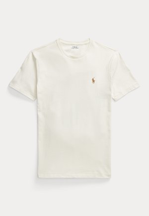 T-shirt ivoire à manches courtes et à col rond, orné d’un petit logo marron représentant un joueur de polo sur la poitrine.