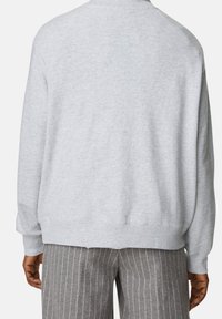 Lichtgrijze sweatshirt met een ontspannen pasvorm, ribgebreide manchetten en zoom, met een zachte textuur en zonder zichtbare patronen of logo's.