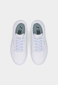 Ζευγάρι λευκών αθλητικών παπουτσιών Puma με κορδόνια, διάτρητη περιοχή στο μπροστινό μέρος και γκρι εσωτερικά πέλματα με το λογότυπο Puma και κωδικούς QR, σε λήψη από πάνω.