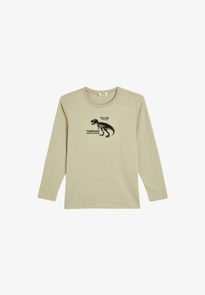 Long-sleeve t-shirt in light beige cotton features a black dinosaur graphic with text: "WILD ZONE" and "TYRANNOSAURUS, DANGEROUS AND POWERFUL."