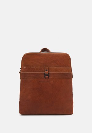 Mochila de cuero marrón con una textura suave, forma rectangular plana, asa superior y cierre con cremallera. Cuenta con una correa decorativa frontal y un logo.