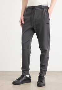 Kulørte joggers i charcoal lavet af et glat stof, med en snor i taljen, ribbede manchetter og et diskret BOSS-logo på venstre lår.