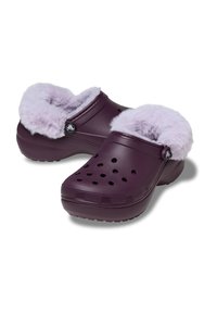 Fioletowe klapki z puszystym lawendowym wyściółką, wyposażone w otwory wentylacyjne, akcent w postaci okrągłego logo oraz zaokrąglony kształt palców. Wykonane z gumy.
