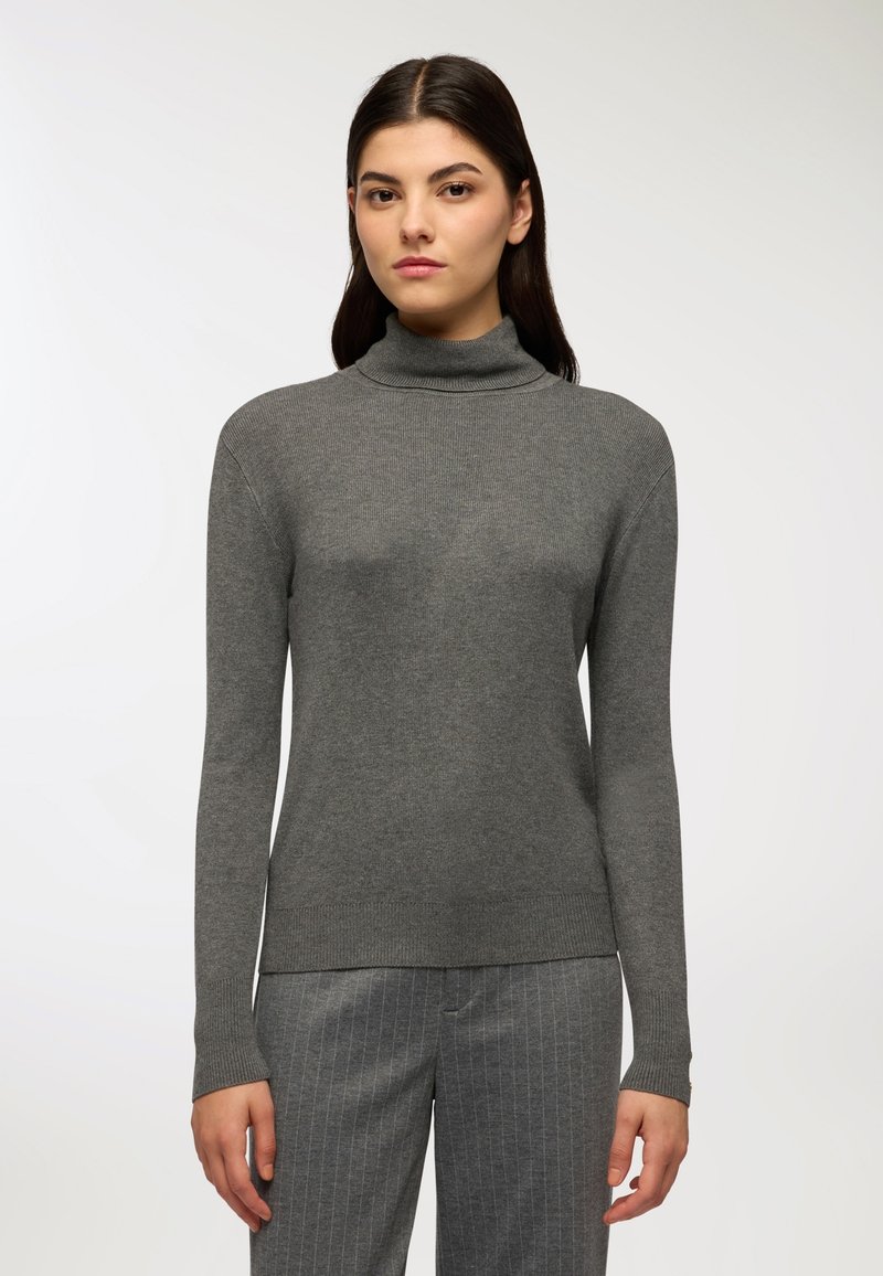 Maglione a collo alto grigio in cotone con texture a coste, maniche lunghe e design aderente; abbinato a pantaloni a righe grigie chiaro.