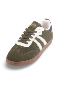 Baskets en daim vert avec rayures blanches, semelle en caoutchouc et accent de talon texturé noir. Caractéristiques : bout rond et fermeture lacée.