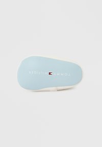 Μπλε σόλα με λευκές λεπτομέρειες, με ένα λογότυπο που γράφει «TOMMY HILFIGER» σε λευκό, με λεία υφή και στρογγυλεμένο σχήμα.